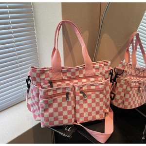 Detail of pink and white checkered corduroy tote bag with dual zippered pockets