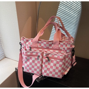 Detailed view of pink checkered canvas tote bag featuring dual front zipper pockets