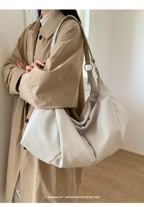 Detail view of the cream pleated tote bag featuring high-quality lychee grain leather
