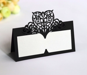 Detail of black laser-cut heart seat card with glitter finish and name writing space