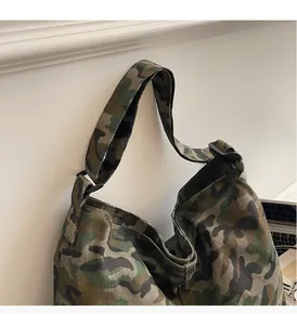 Close-up of wide strap with black adjustment buckle on camouflage canvas tote bag