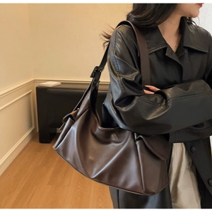 Détail du grand sac cabas marron foncé avec large bandoulière et boucle en métal noir
