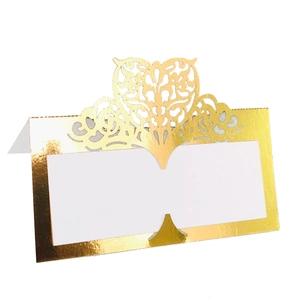 Detail view of laser-cut heart pattern on gold metallic place card for wedding decor
