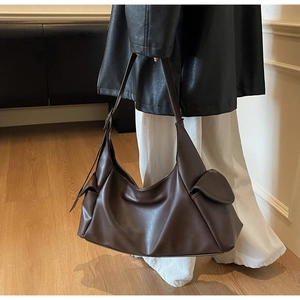 Détail d'un sac hobo marron foncé montrant le similicuir texturé et une poche latérale