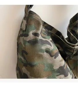 Close-up of durable canvas texture and military camo pattern on large shoulder tote bag