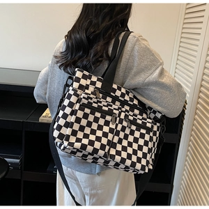 Detailed view of the large capacity checkerboard tote bag with dual front zip pockets
