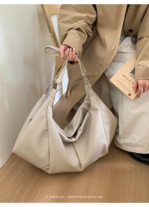 Close-up of beige lychee grain leather tote bag with elegant pleated texture and silver ring