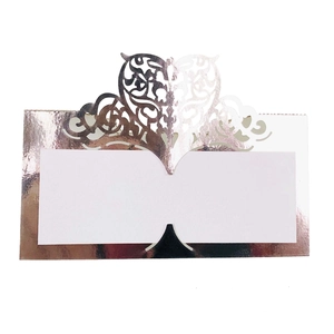 Close-up of rose gold laser cut place card with intricate hollow heart and vine details