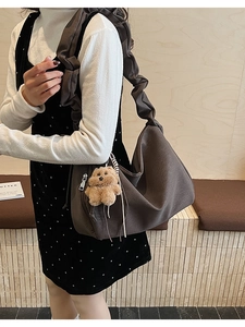 Detail of dark coffee tote bag with ruched cloud shoulder strap and a cute plush bear charm