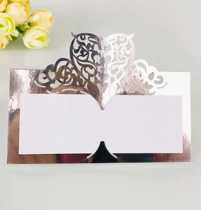 Detail of laser-cut heart pattern on rose gold wedding place card with white insert