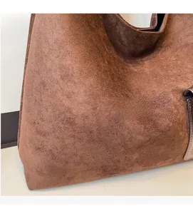 Close-up of brown suede tote bag showing soft matte texture and premium side stitching