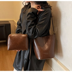 Detail view of retro brown bucket bag and clutch with vintage oil wax leather texture