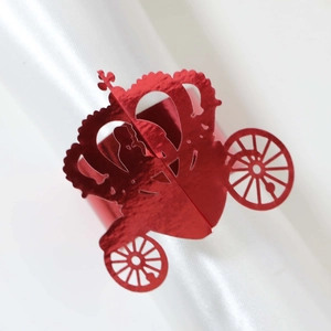 Macro detail of red metallic carriage napkin ring with laser-cut hollow crown patterns
