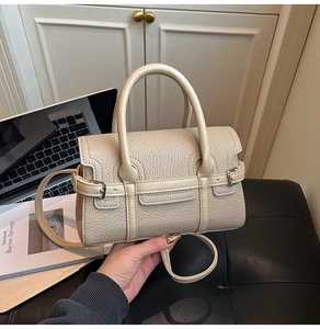 Detail der beigen Handtasche aus genarbtem Leder mit silbernen Schnallen-Akzenten