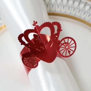 Close-up of bright red laser-cut pumpkin carriage napkin ring on white satin cloth