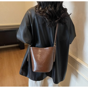 Brown leather bucket bag with vintage texture and fine strap shown in a back view