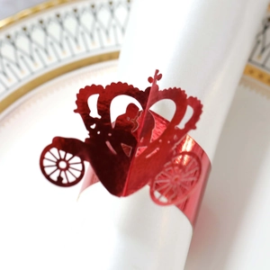 Macro shot of red laser-cut carriage and crown napkin ring for wedding table decor