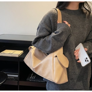 Vue détaillée du grand sac à bandoulière abricot montrant le cuir synthétique de qualité