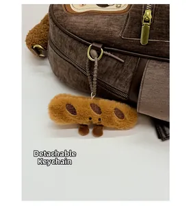 Detail of dark brown corduroy backpack featuring a detachable plush baguette charm