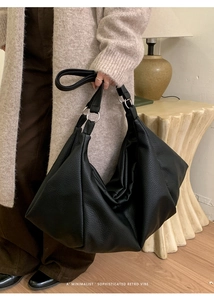 Detail of black pebbled leather hobo bag with silver ring hardware in a retro interior