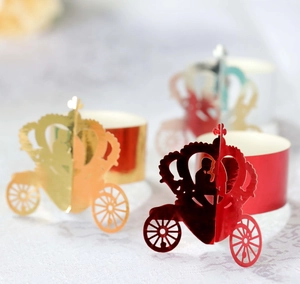 Macro detail of laser-cut pumpkin carriage paper napkin rings in gold and red finish