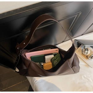 Vue macro du sac hobo marron montrant un intérieur spacieux avec tablette et mobile