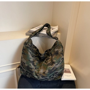 Detail of a large camouflage canvas tote bag placed on a decorative home background
