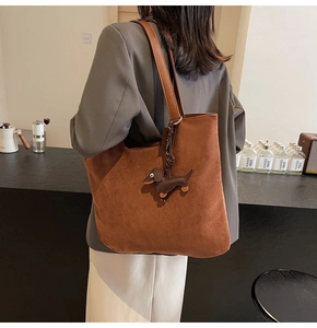 Détail du grand sac cabas en daim marron avec un joli pendentif en cuir en forme de teckel