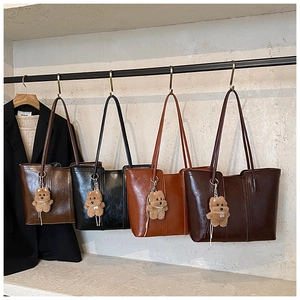 Detailed display of large tote bags in four colors with plush bear charms for commuting
