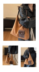 Detail of a large brown suede tote bag featuring a leather pocket and long shoulder straps