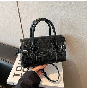Detail der schwarzen Handtasche aus Kieselleder mit Kontrastnähten und Doppelgriffen