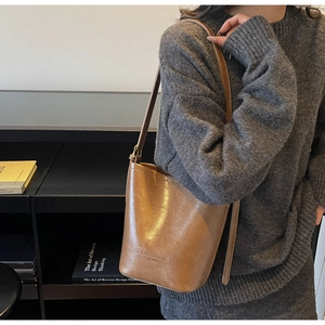 Detailed view of the brown retro bucket bag showing textured leather and fashion branding