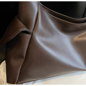 Détail de la texture cuir litchi et du design plissé sur ce grand sac cabas marron café
