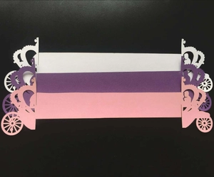 Detail showing laser-cut Cinderella carriage paper napkin rings in red, white and purple