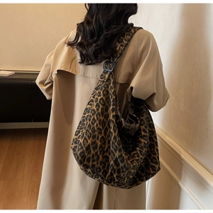 Detail of leopard print canvas tote bag shown on model with adjustable strap