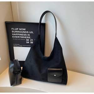 Dettaglio di borsa hobo in camoscio nero con spalline in pelle e pochette coordinata
