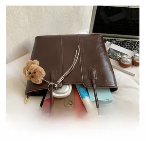 Close-up of the spacious interior of this dark brown tote bag holding everyday essentials