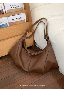 Detail of vintage brown pleated tote bag with荔枝 texture and silver metal buckle hardware