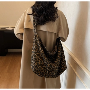 Macro detail of large canvas leopard print tote bag with wide strap on model