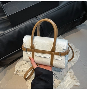 Detail der Kontrast-Handtasche aus Leder mit Lychee-Muster, Griff und Gürtelschnalle