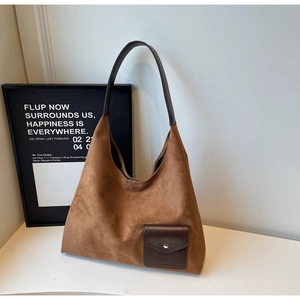 Dettaglio borsa tote grande in camoscio marrone con tracolla e tasca con bottone