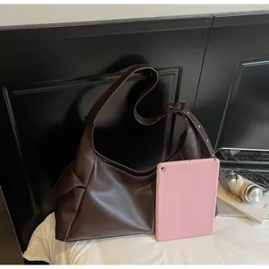Vue détaillée de la grande capacité du sac demi-lune marron avec comparaison de tablette