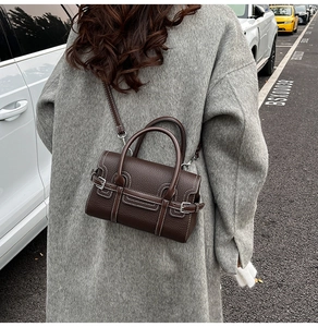 Detailansicht der dunkelbraunen Lederhandtasche mit stilvollen weißen Kontrastnähten