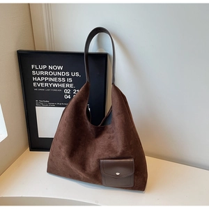 Dettaglio borsa tote in pelle scamosciata marrone con tasca lucida e bottone in metallo argento