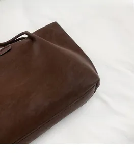 Close-up of deep brown tote bag showing smooth faux leather texture and premium material