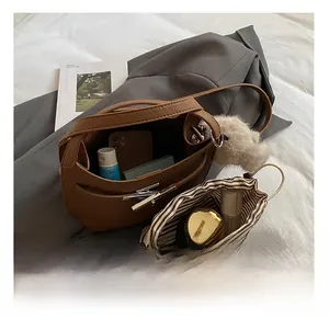 Detail view of brown lychee-patterned bucket bag showing interior capacity and striped pouch