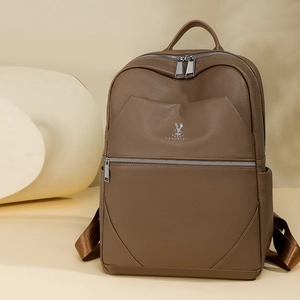 Detailed macro view of the brown lychee grain texture and silver metal rabbit logo on backpack