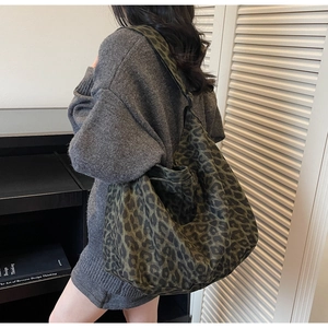 Close-up of leopard print canvas tote bag with wide shoulder strap in green and brown
