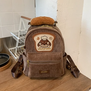 Detail of corduroy backpack with chef puppy embroidery and faux bread handle texture