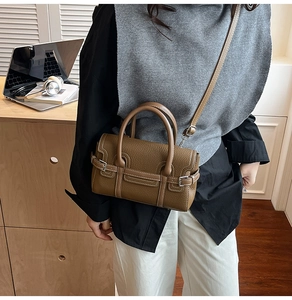 Detail der dunkelbraunen Lederhandtasche mit Lychee-Maserung und silbernen Schnallen